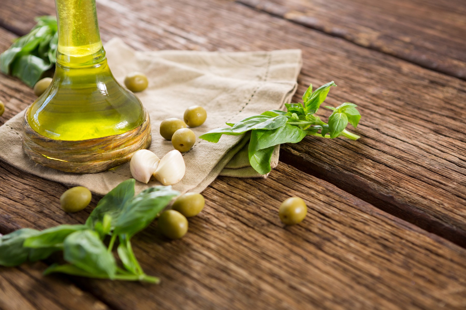 Olive oil and ingredients on wooden table