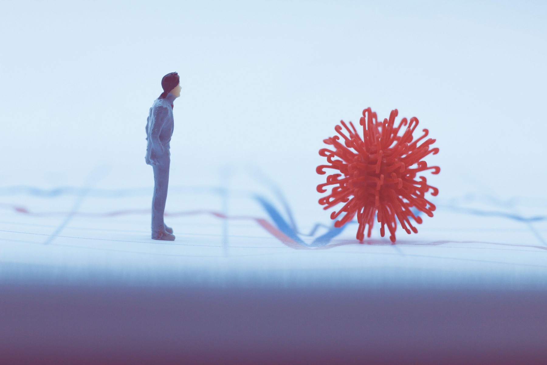 Man and virus cell laying on a stock graph. Concept of global crisis.