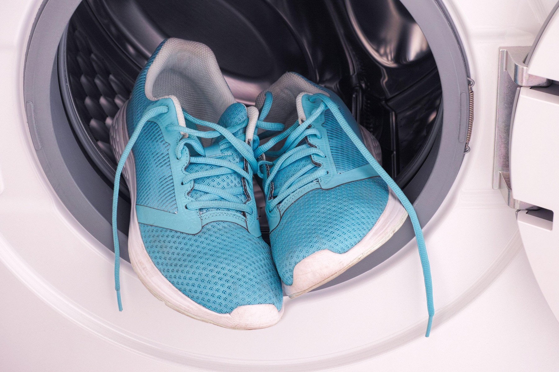 Sneakers inside the washing machine. Close up.