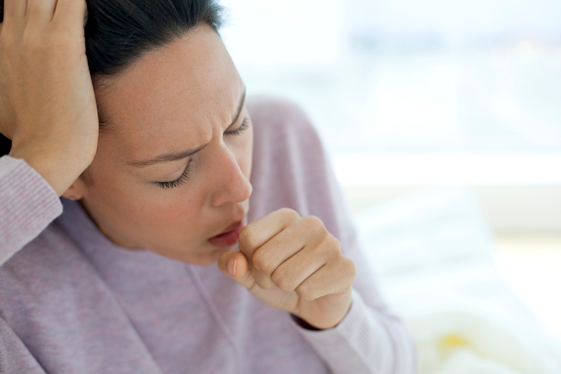 Young woman coughing