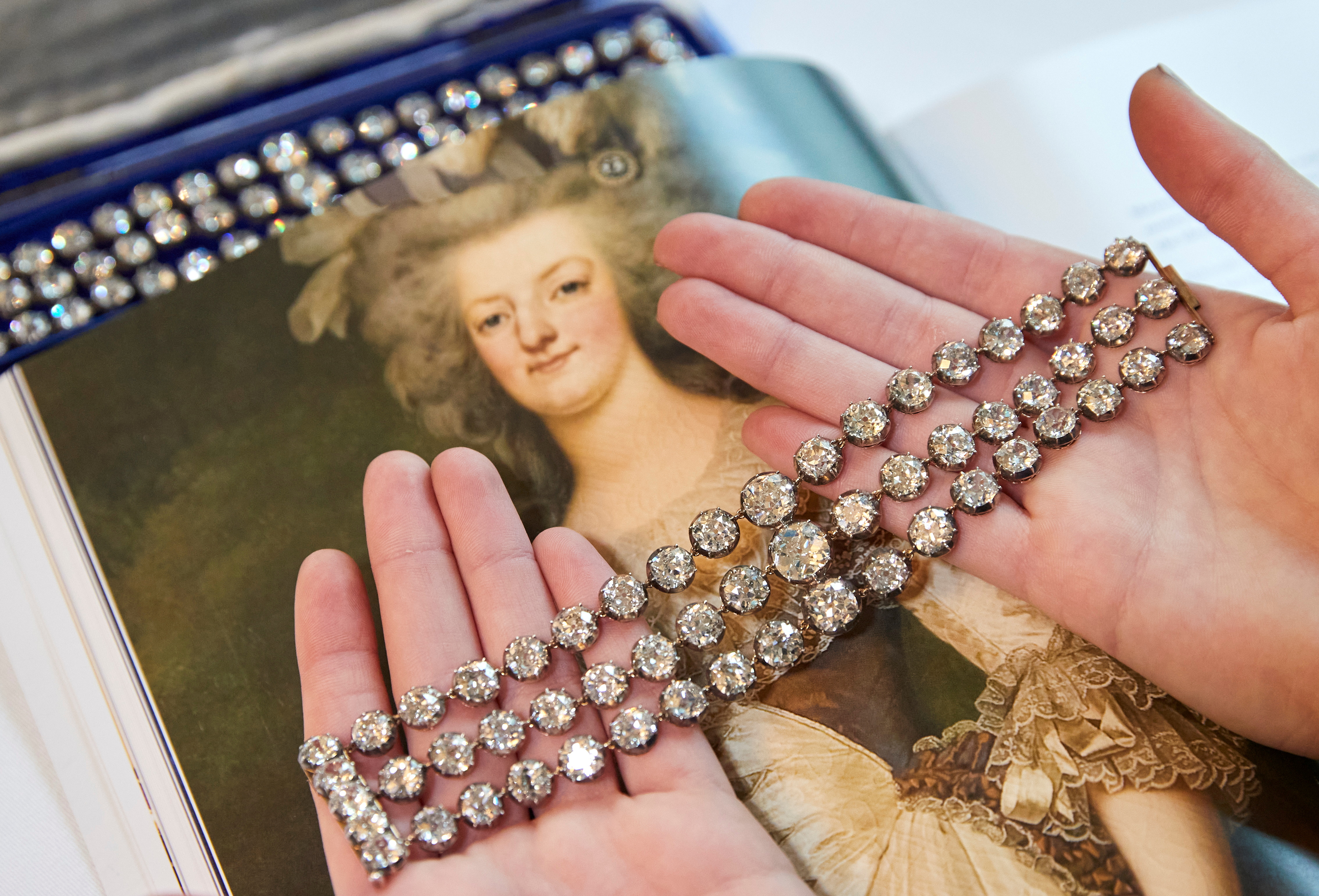 FILE PHOTO: A staff displays a pair of diamond bracelets before their auction sale in Geneva