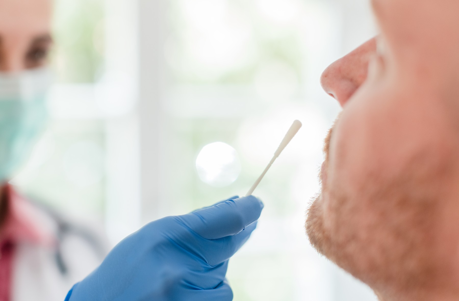 Doctor inserting swab in patients nose for Covid 19 test