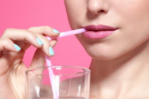 Close up of woman drinking with straw