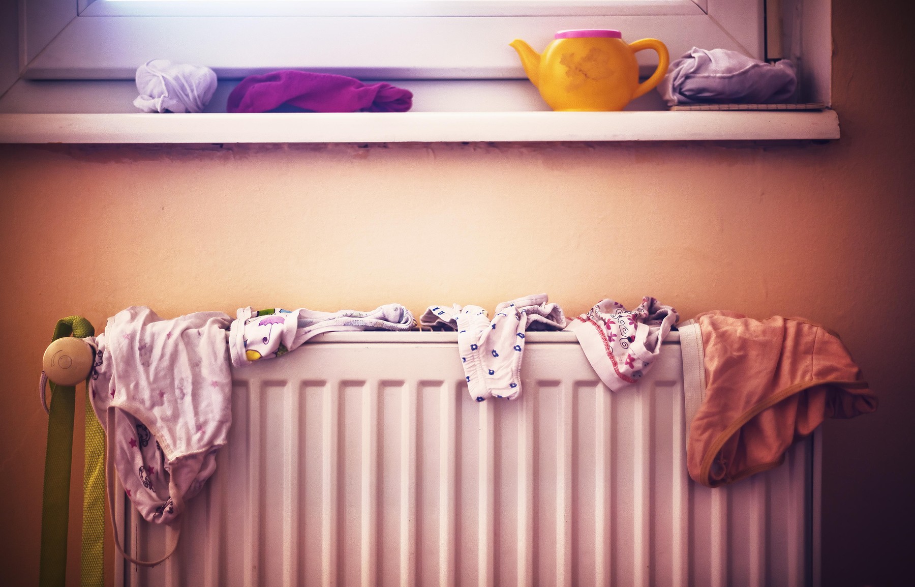 Details of everyday family life, wet children's underwear on radiator.