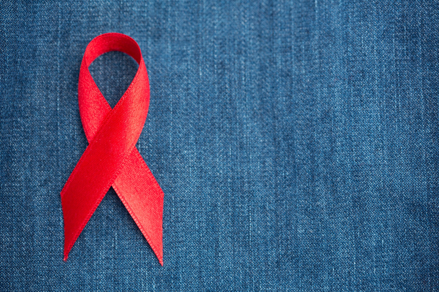 Red ribbon for aids awareness on denim
