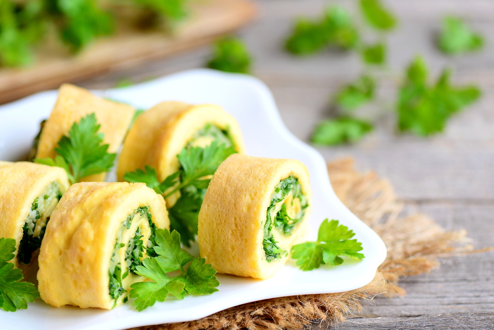 Home,Cheese,And,Parsley,Stuffed,Omelet,Rolls,On,A,Plate.