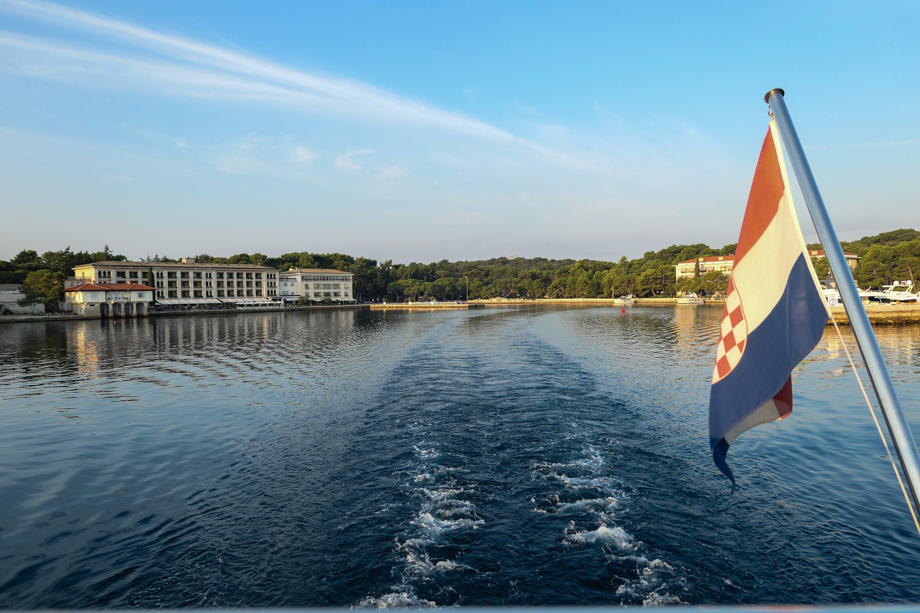 a flaming Croatian flag on a boat leaving Brijuni Bay