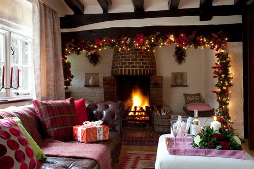 Fairylights garland above lit fire in timber framed Sussex home  UK