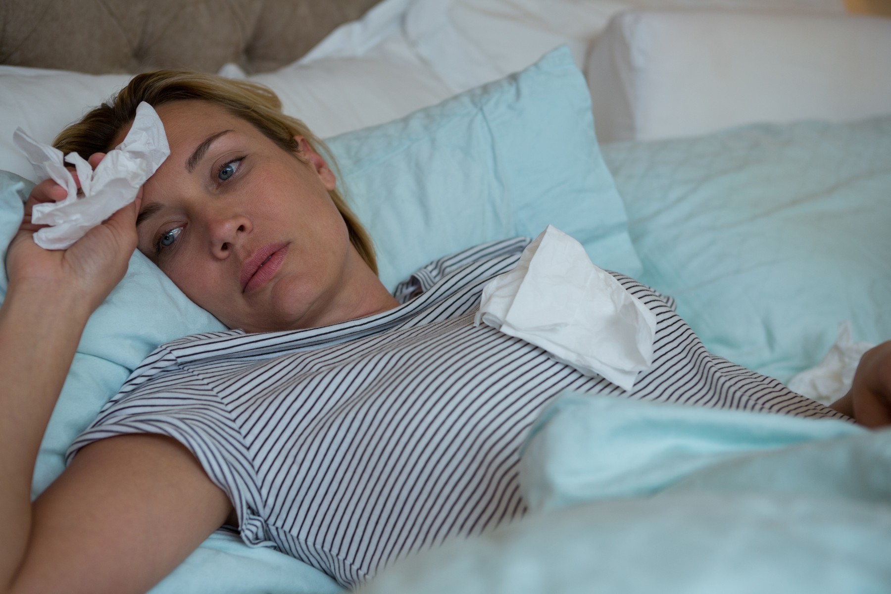 Sick woman lying on bed