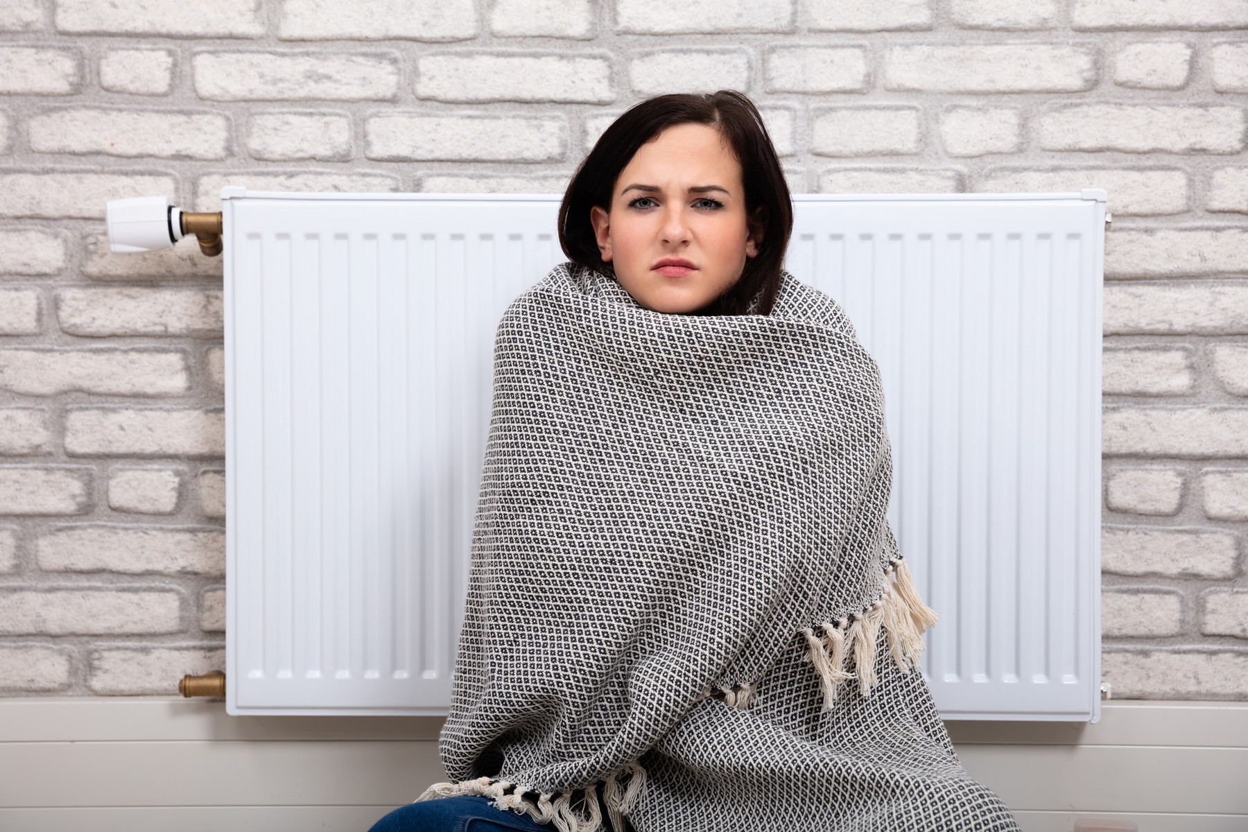 Woman In Blanket Sitting Near Radiator