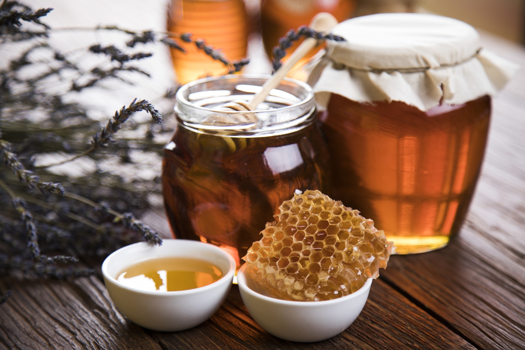 Honey jar with dipper and flowing honey