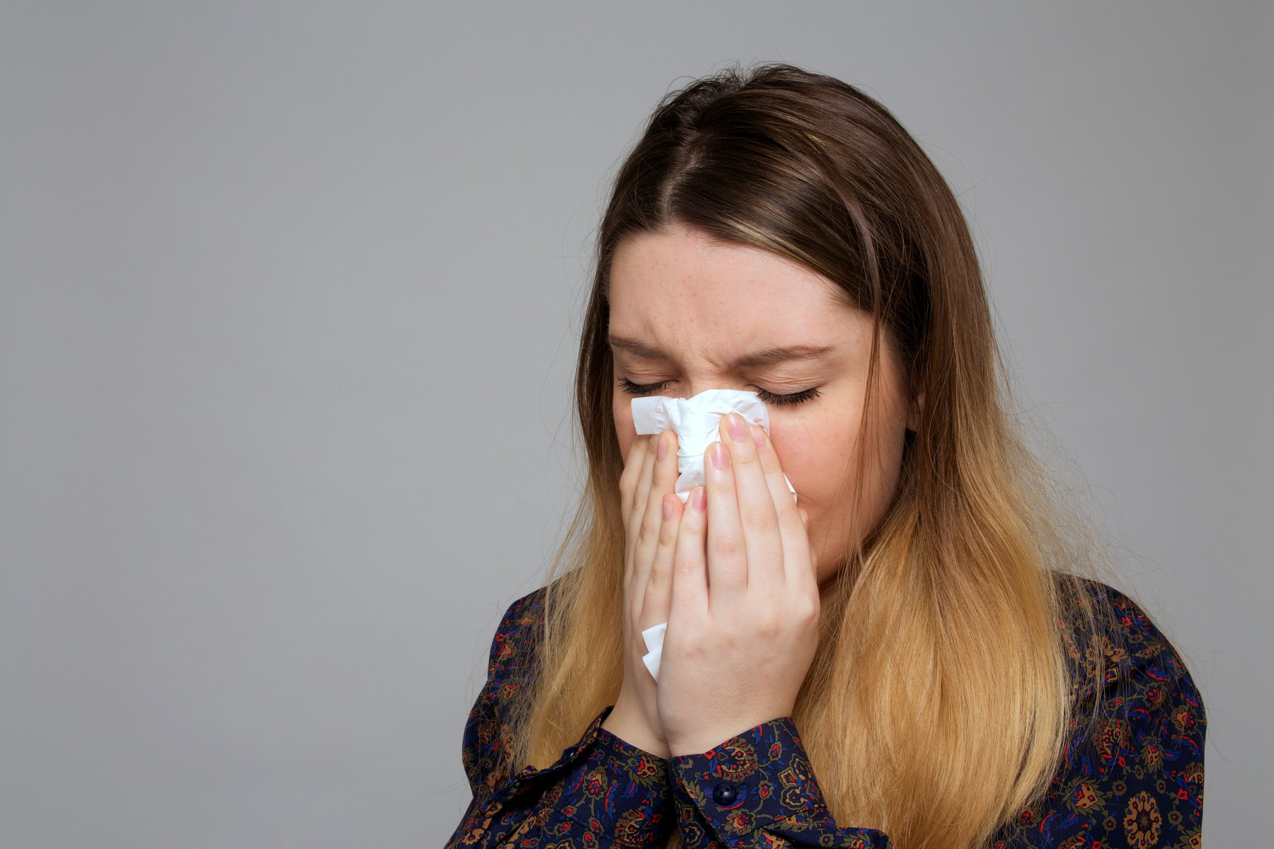 Teenage girl sneezing