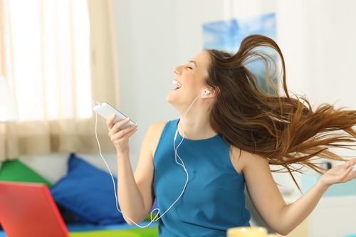 Teen listening music and dancing in her room