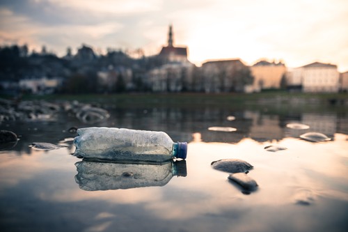 Environmental pollution: plastic bottle on the beach, urban city