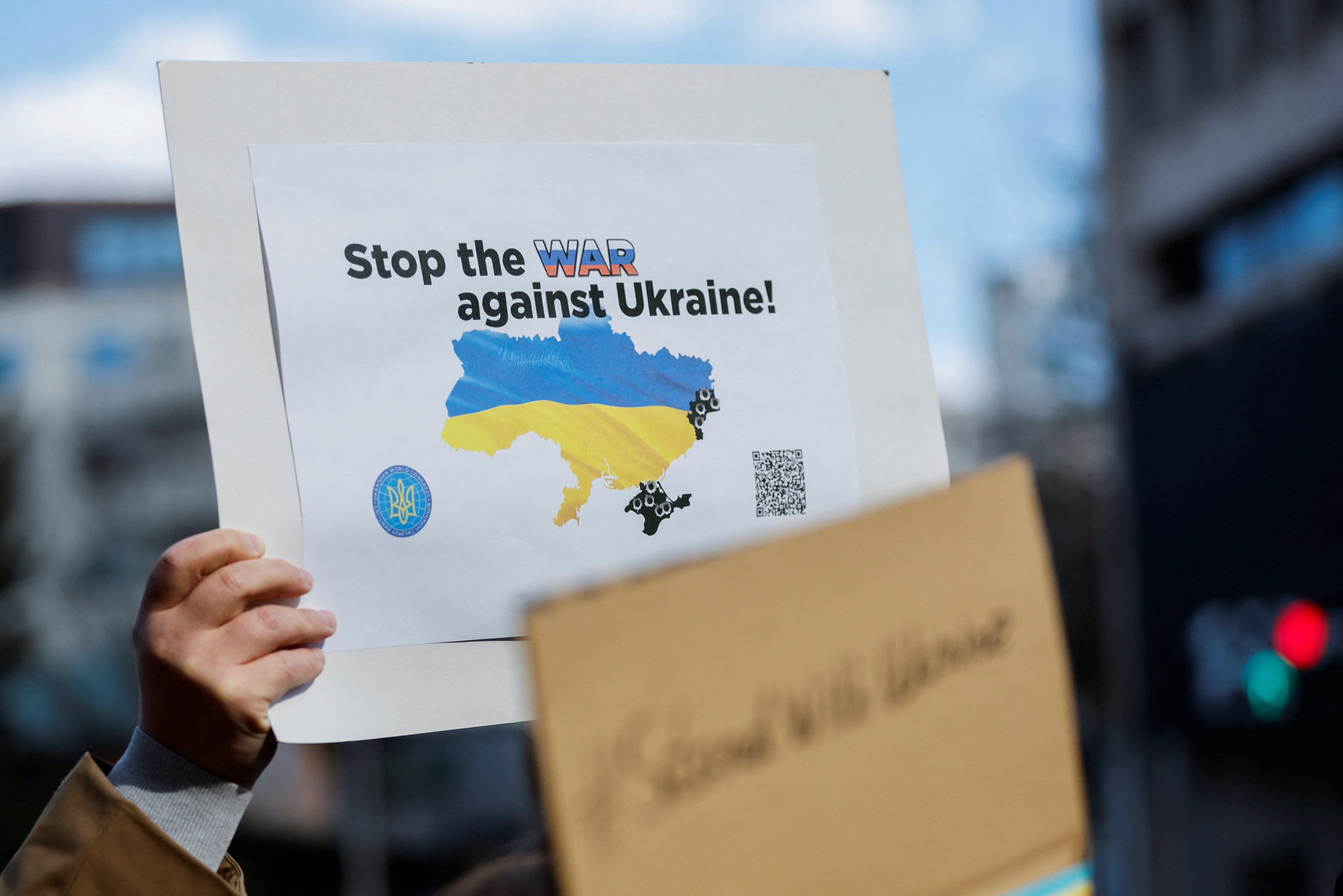 ukrajina, A Ukrainian residing in Japan shows a placard during a protest rally denouncing Russia over its actions in Ukraine, near Russian embassy in Tokyo