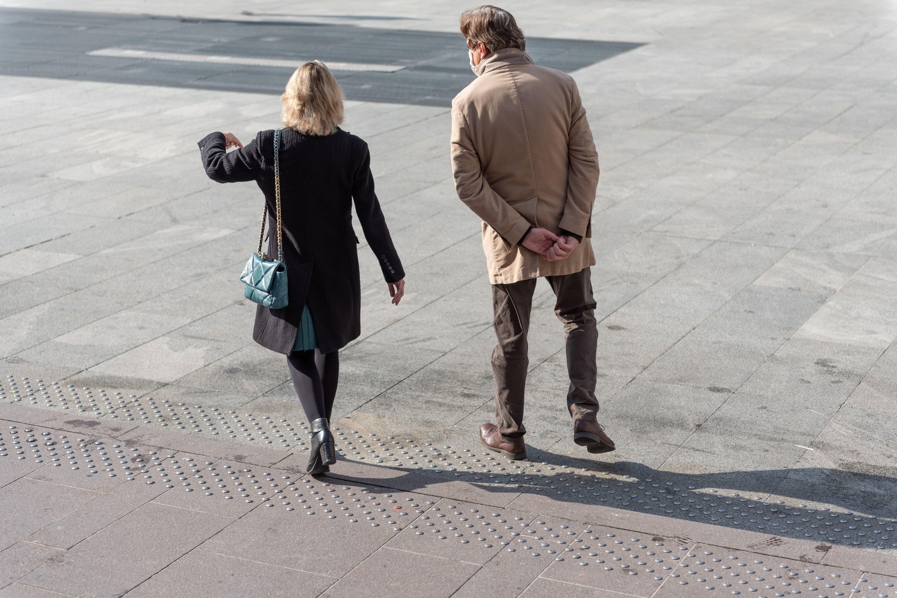 Woman and man walking in the city wearing a medical mask to prevent covid-19