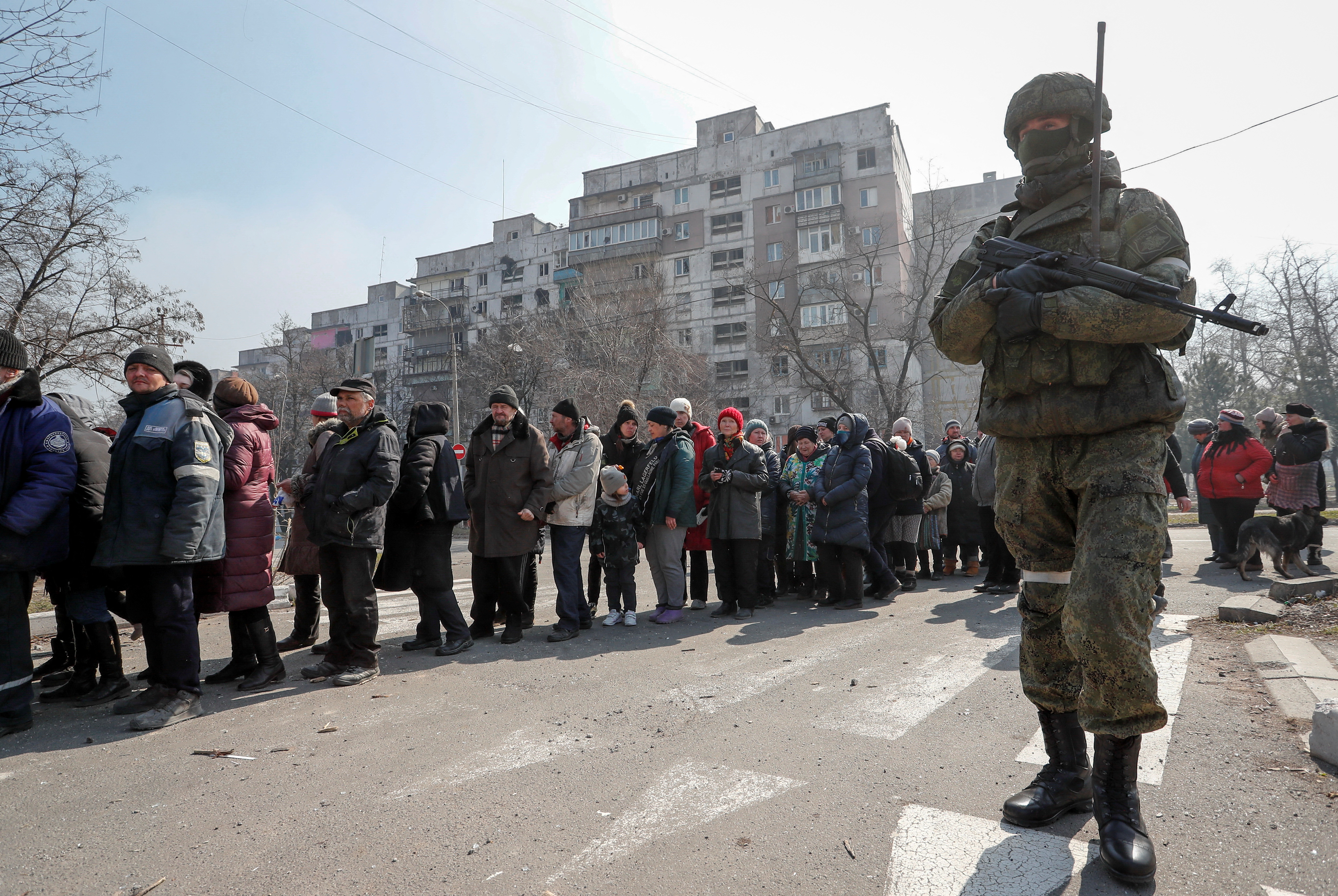 Local residents queue for humanitarian aid in the besieged southern port of Mariupol