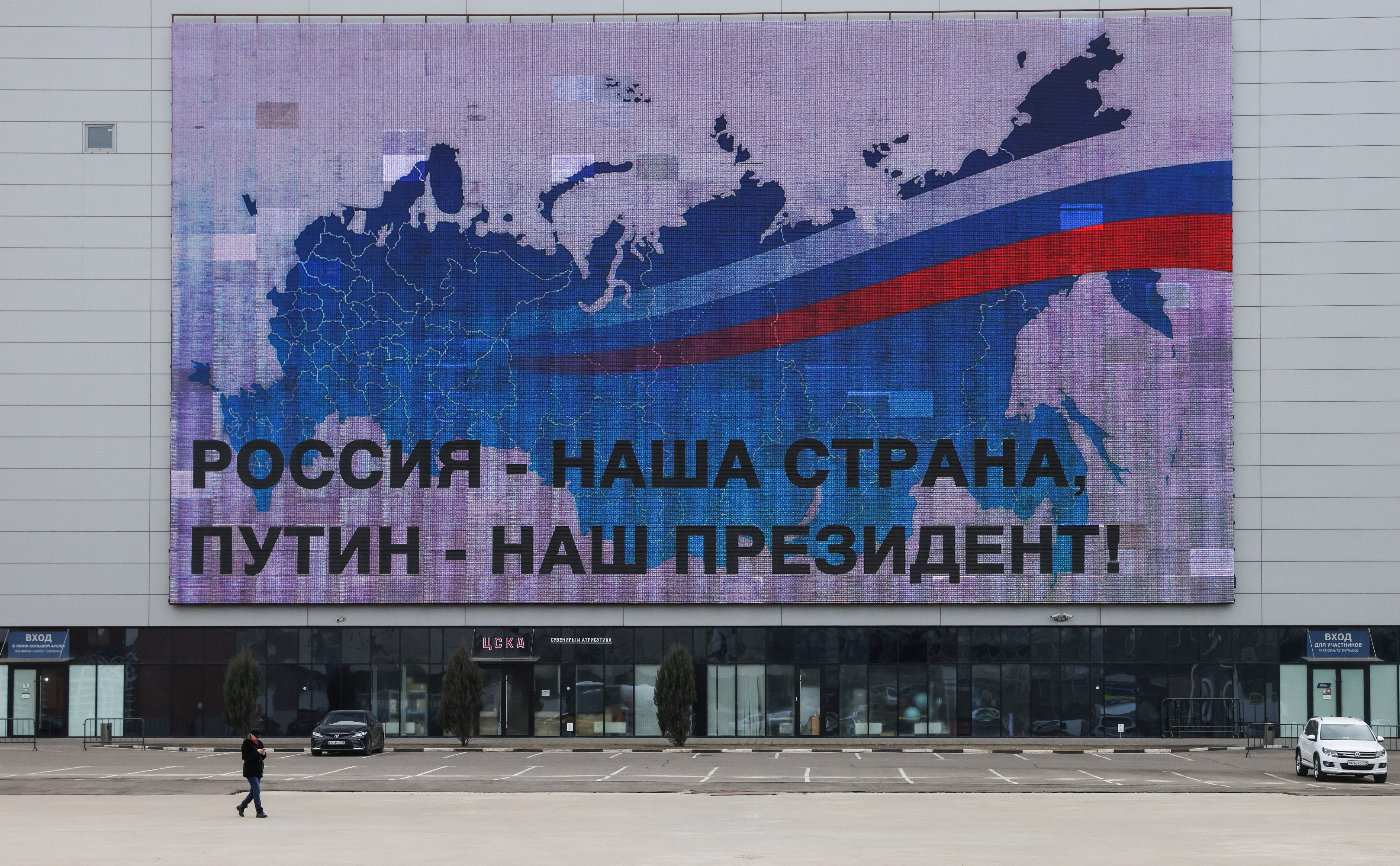 A man walks past an electronic screen in Moscow