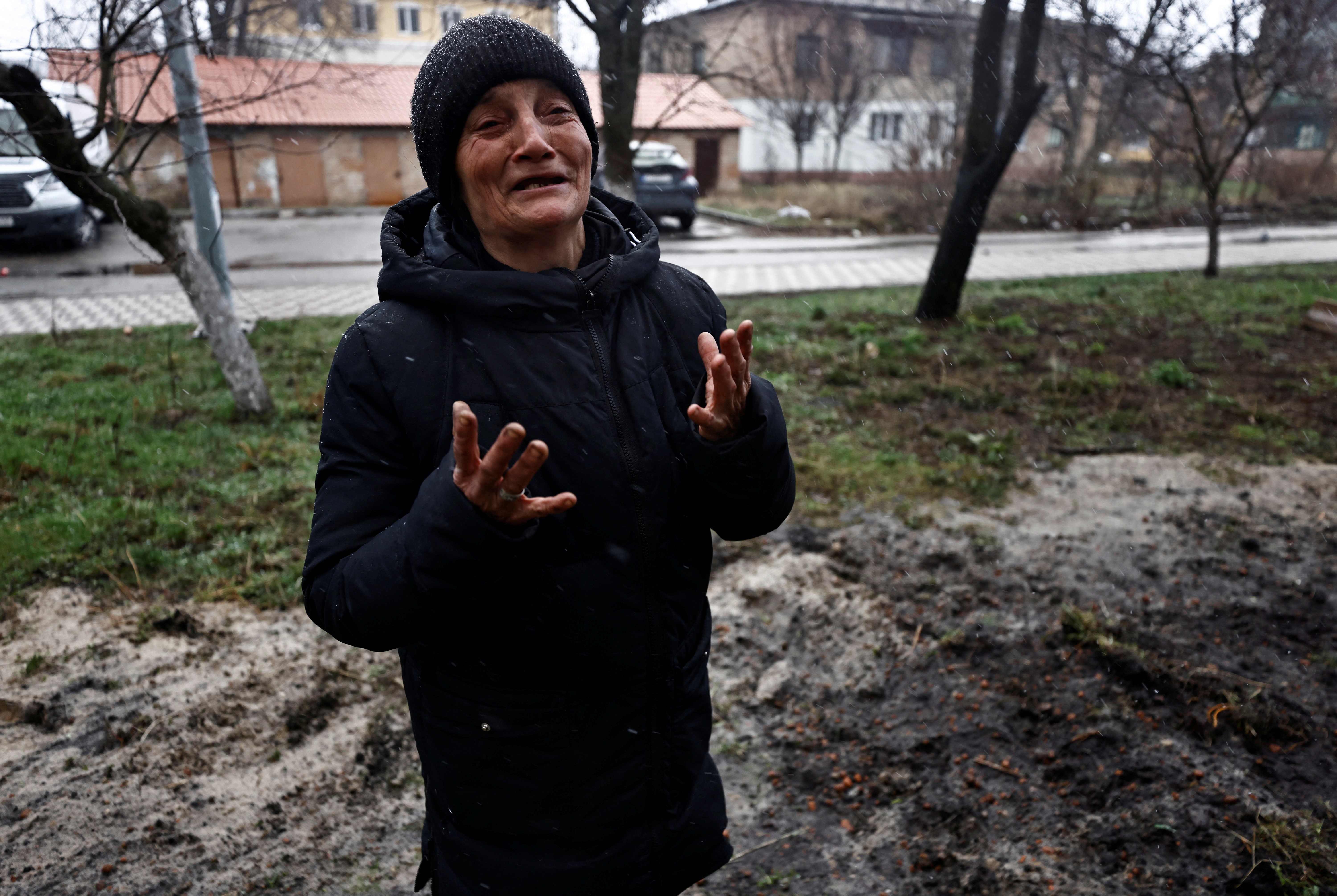 Tanya Nedashkivska, reacts as she mourns her husband Vasyl Ivanovych, who was killed by Russian soldiers, next to his grave at the garden of their residential building, in Bucha