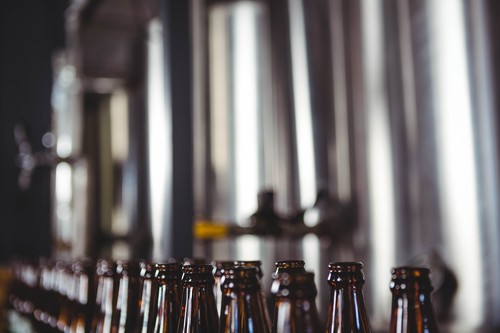 Large vats of beer with bottles