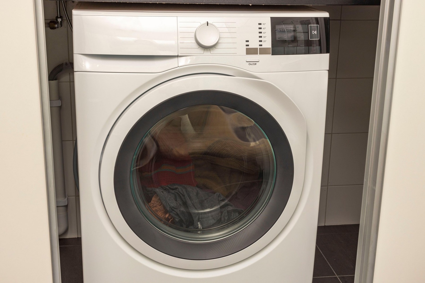 lose-up view of Interior view of laundry cabinet with washing machine.
