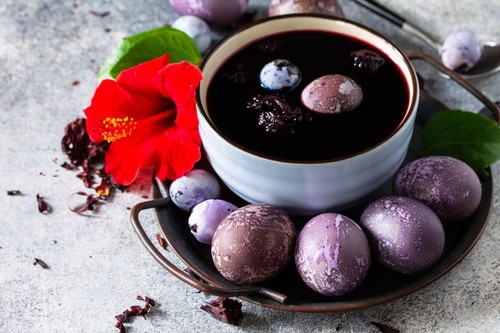 Natural egg dye purple. Easter eggs are painted with natural egg dye from Hibiscus tea on a gray stone countertop.