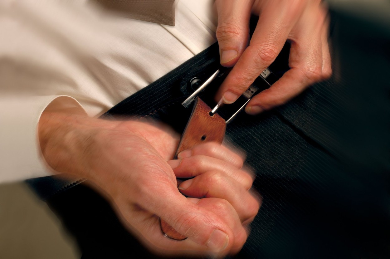 Man tightening belt