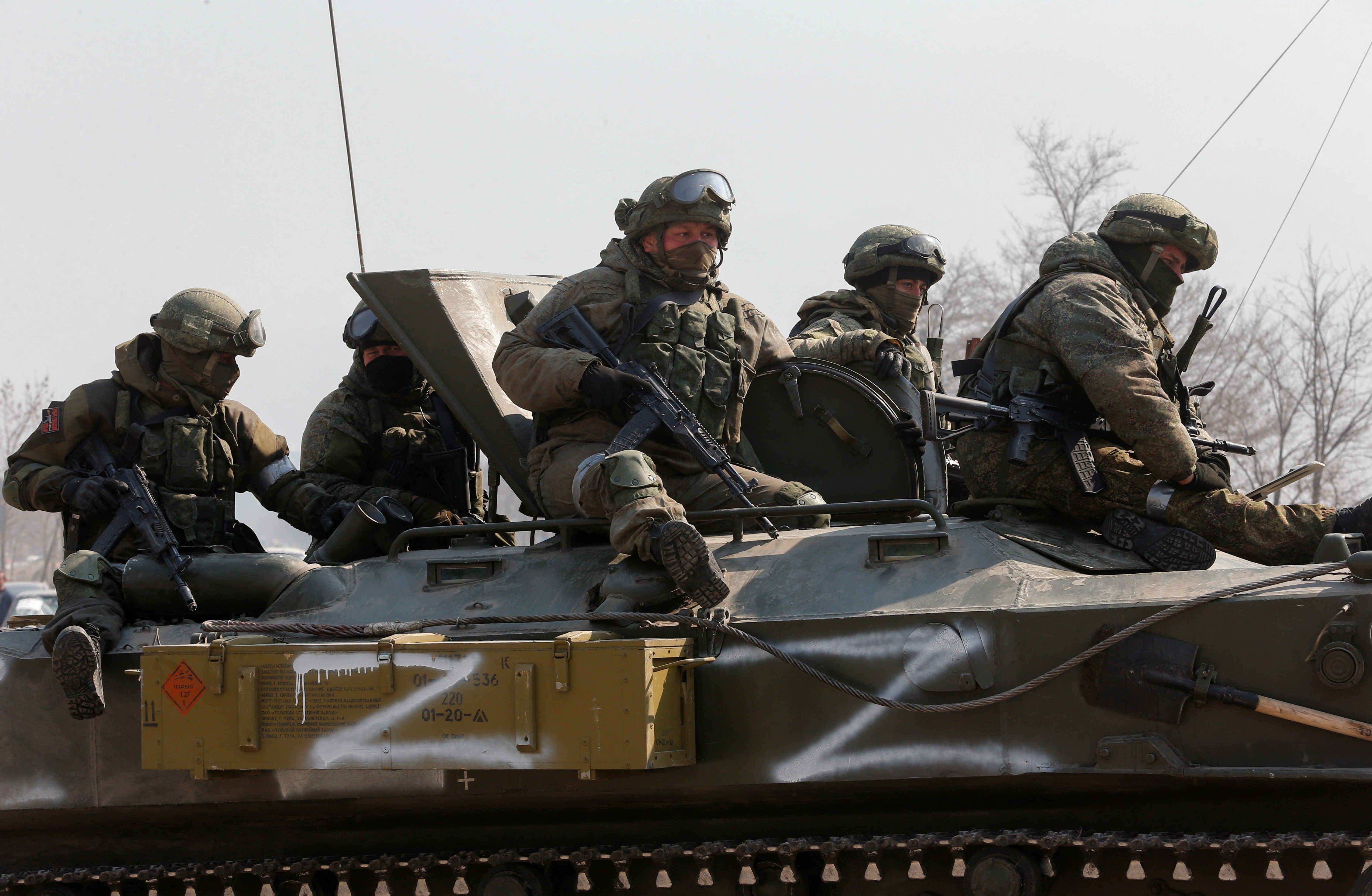 Service members of pro-Russian troops are seen atop of an armoured vehicle in the besieged city of Mariupol