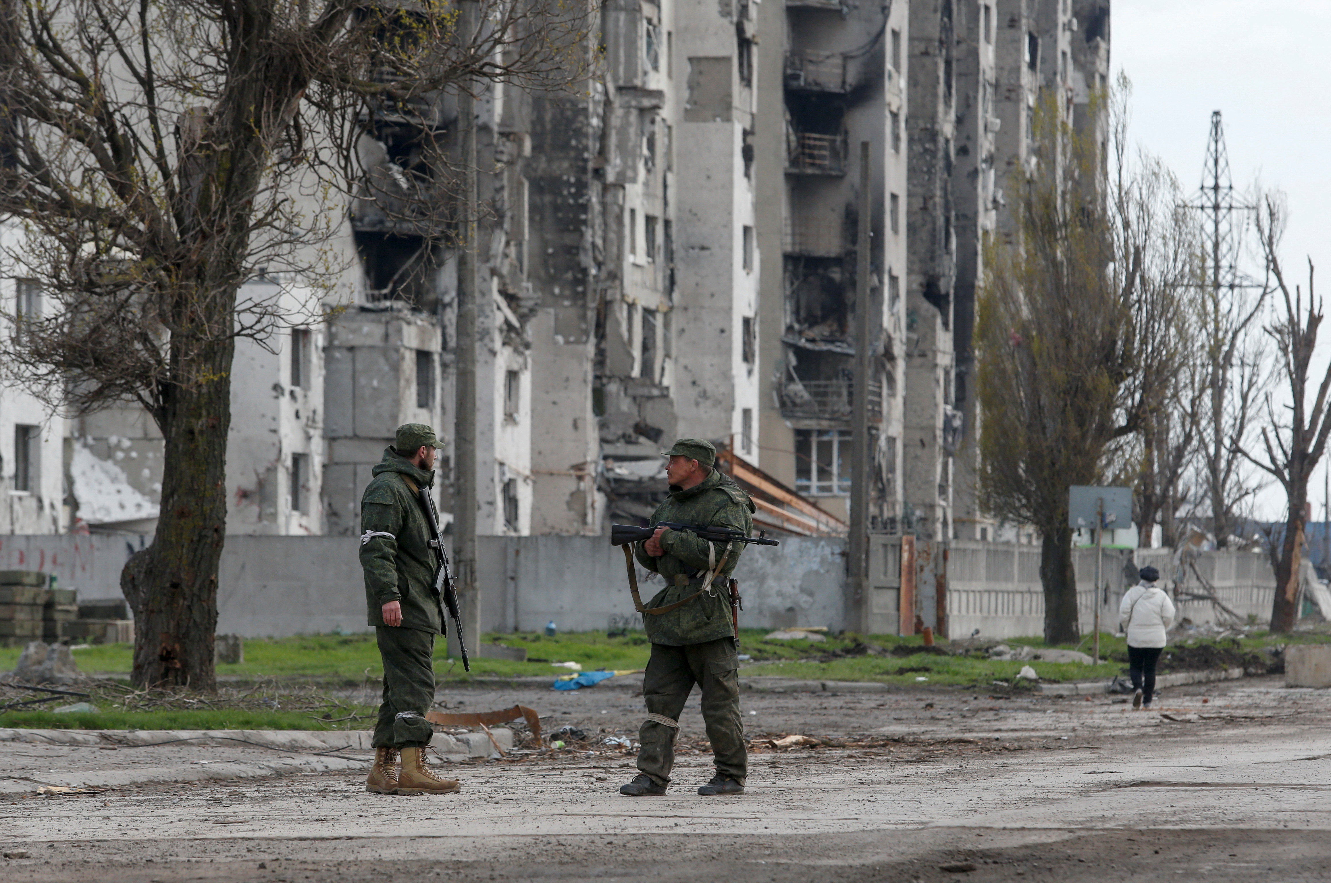 Service members of pro-Russian troops stand guard in a street in Mariupol