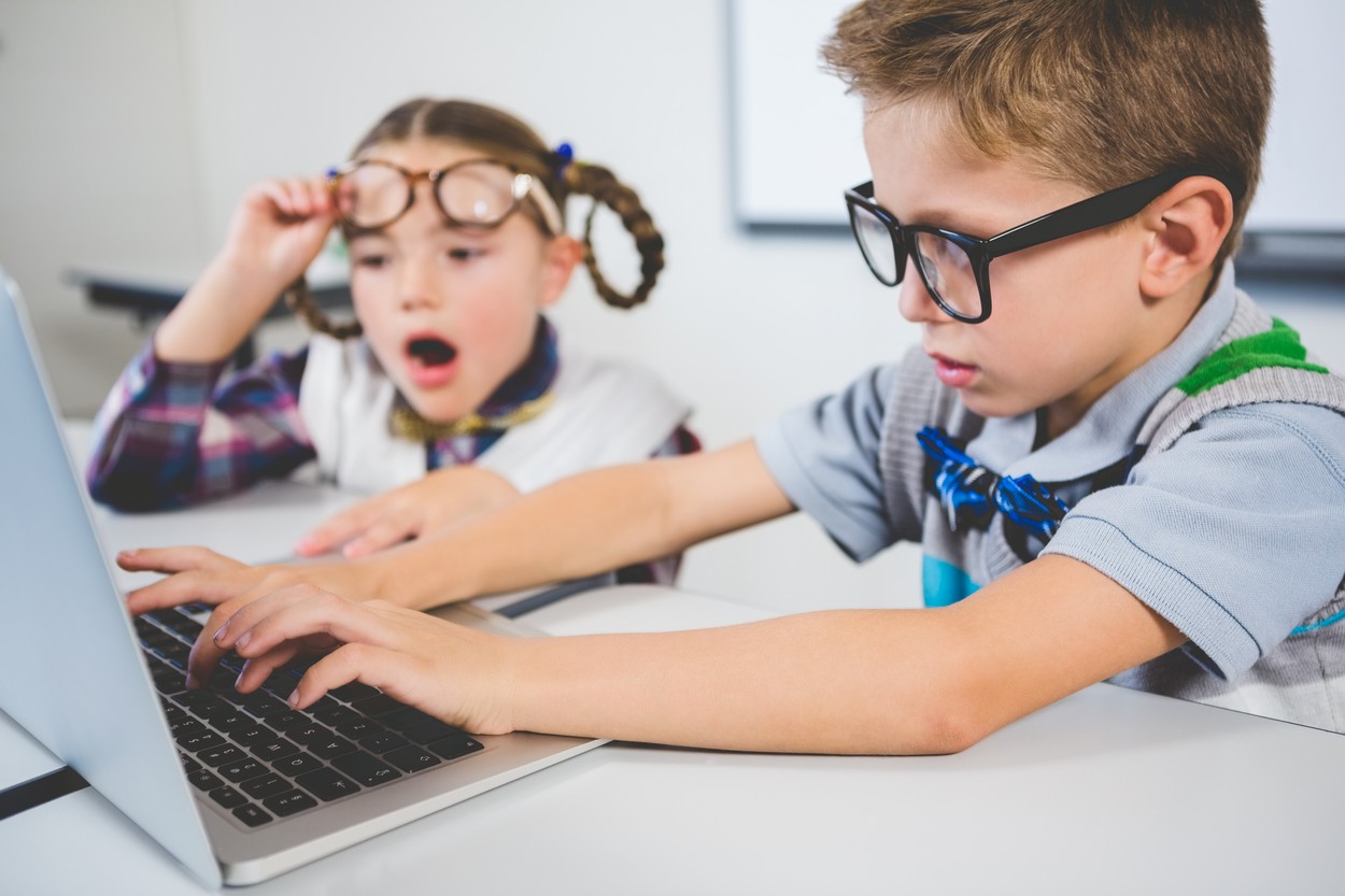 School kids using a laptop in classroom at school