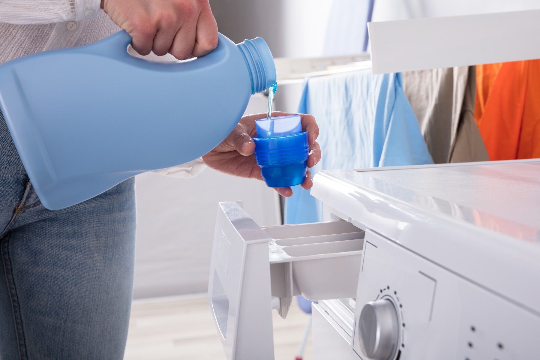 Person Pouring Detergent In Lid