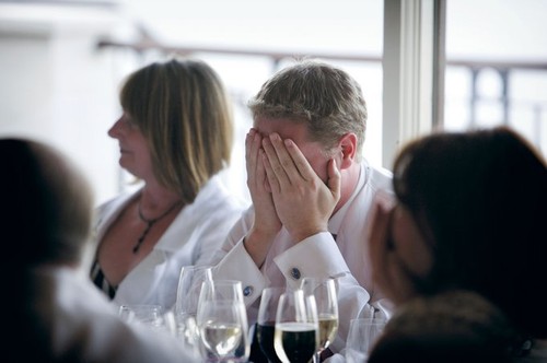 Groom holding hands to his face during wedding speeches