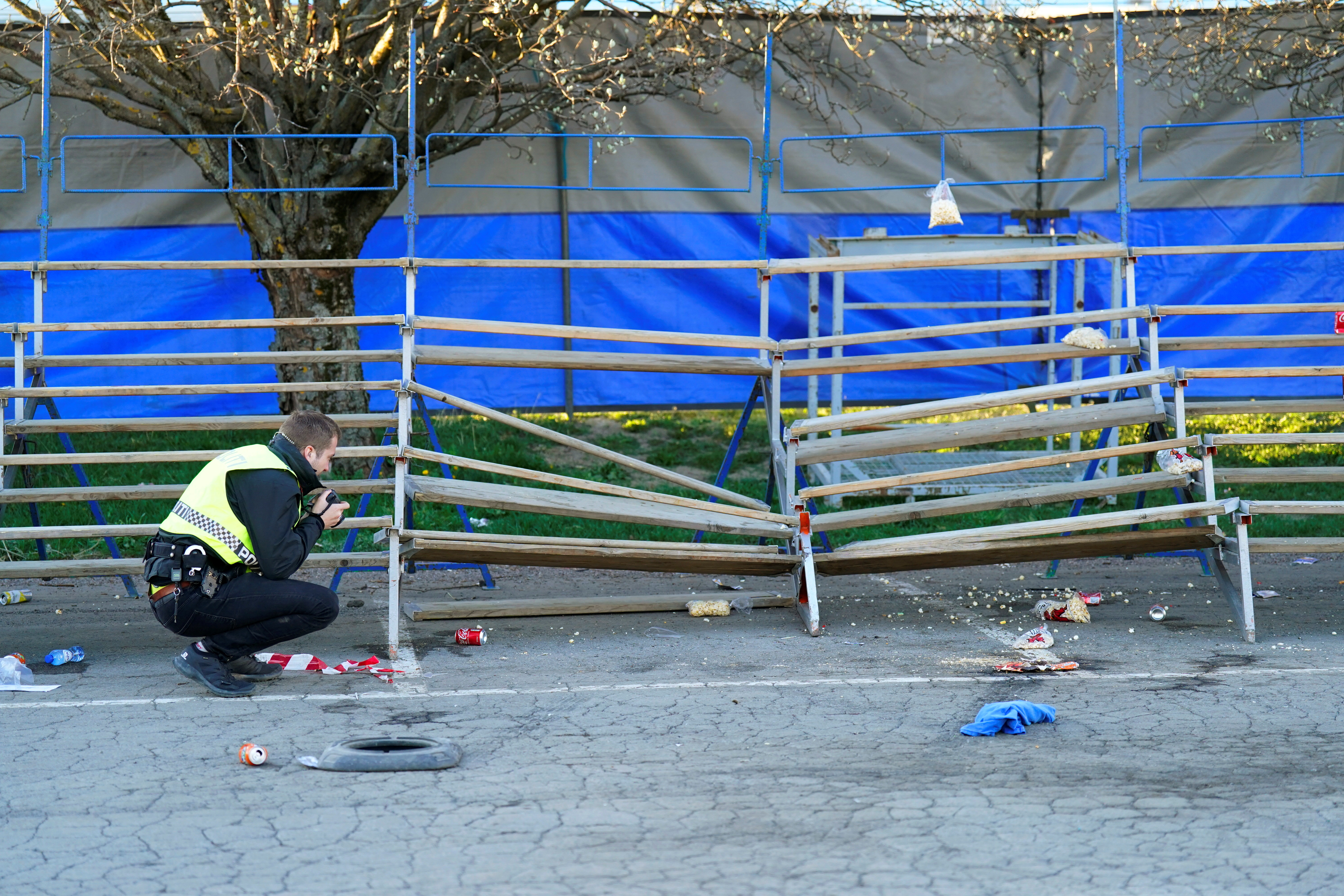 A police officer inspects a grandstand after a car drove into it during a motorshow, at Bjerkebanen in Oslo