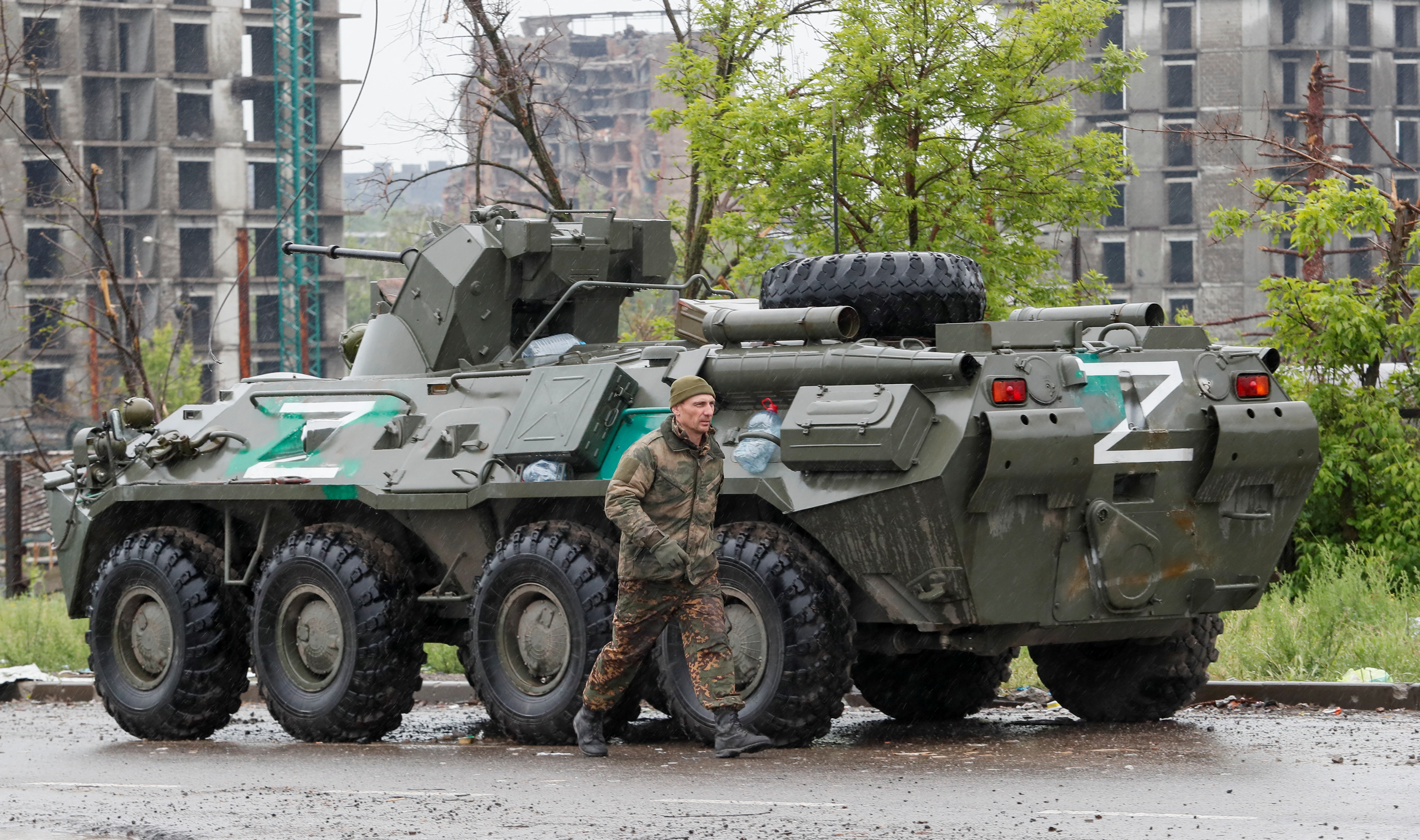 Service members of pro-Russian troops walk in Mariupol