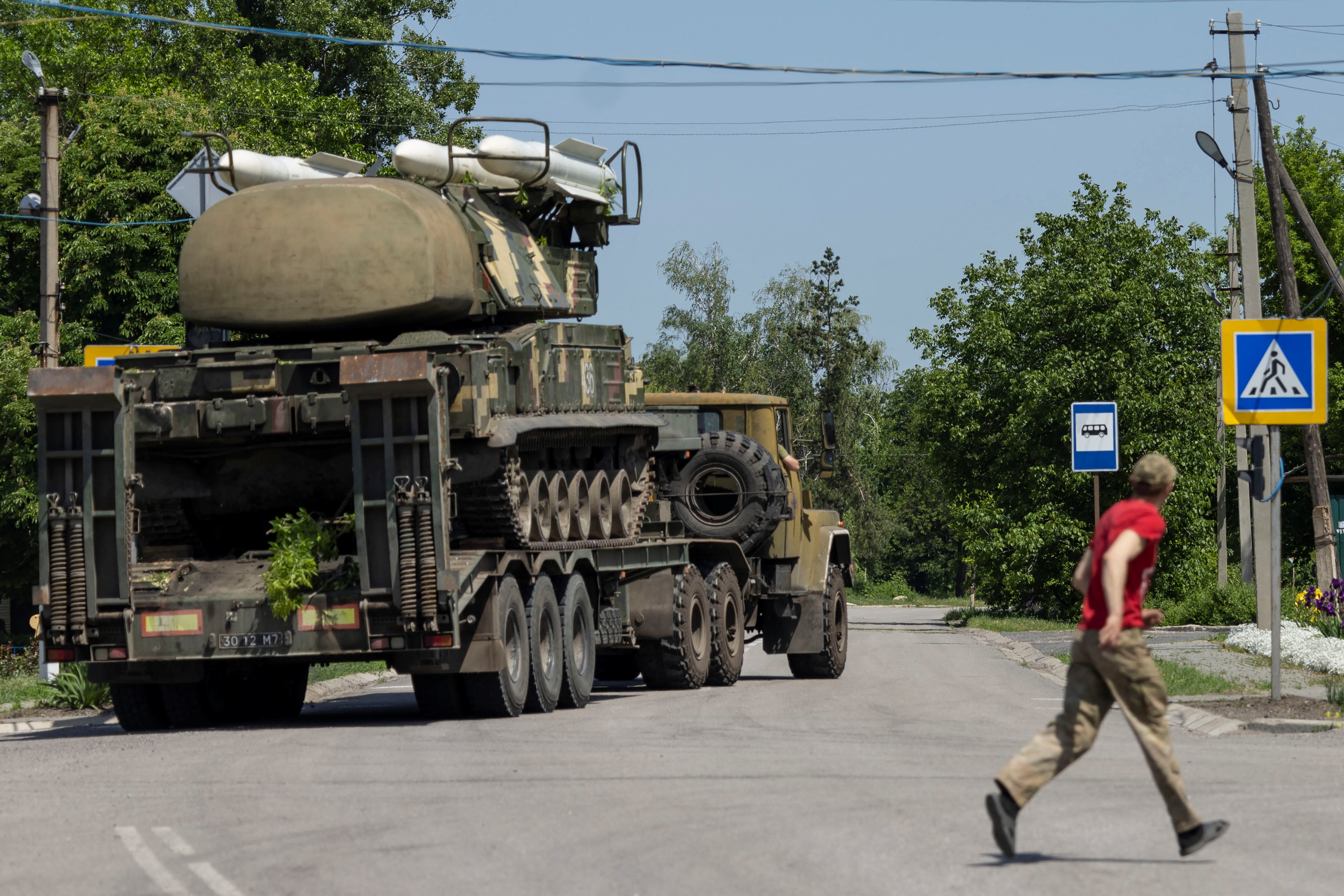 Resident looks at Ukrainian rocket launcher vehicle being transported near Kramatorsk, Donetsk