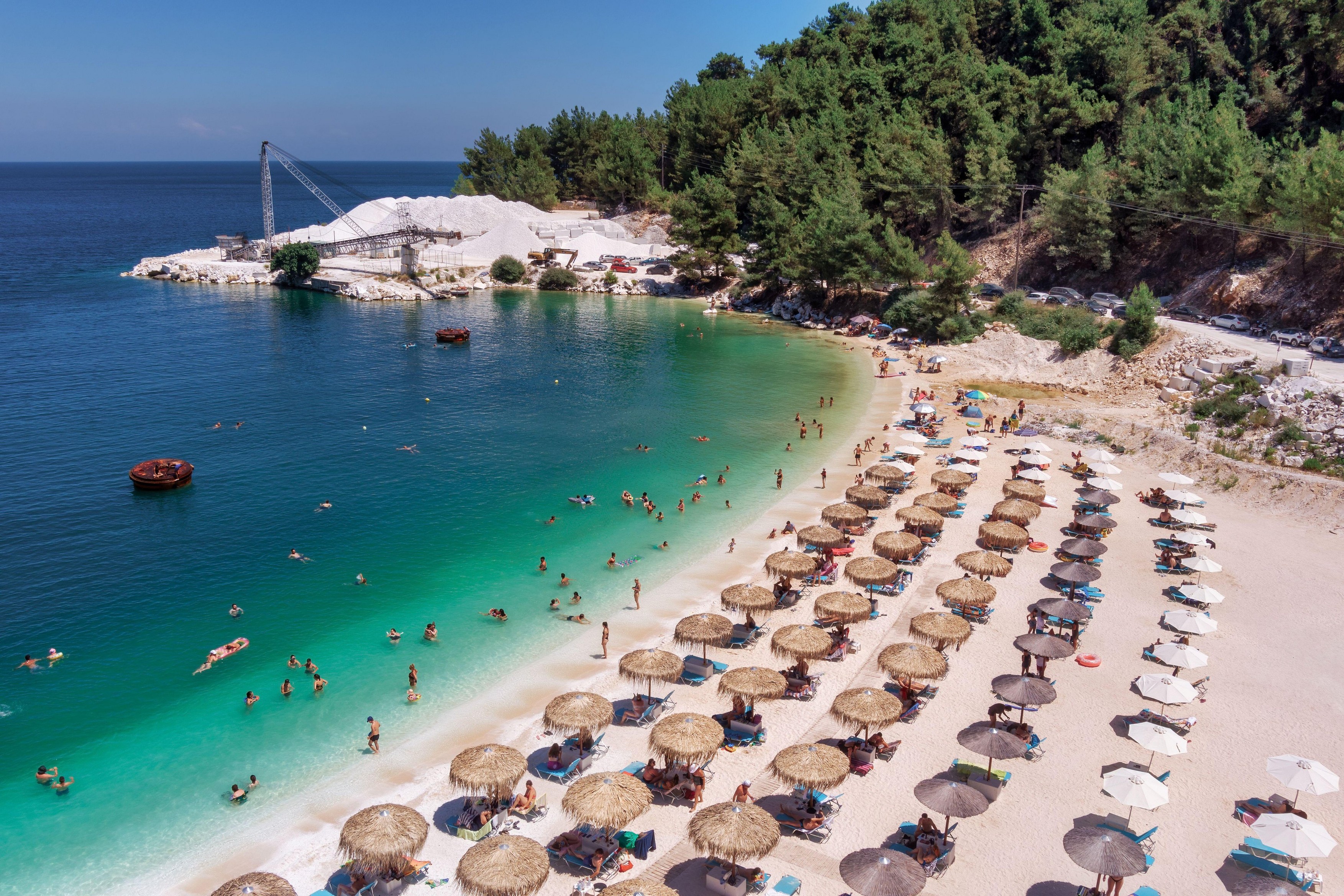 Porto Vathy, Marble Beach, Thassos, Greece- July 19, 2021: aerial view of the Porto Vathy beach of an emerald and transparent Mediterranean sea with a