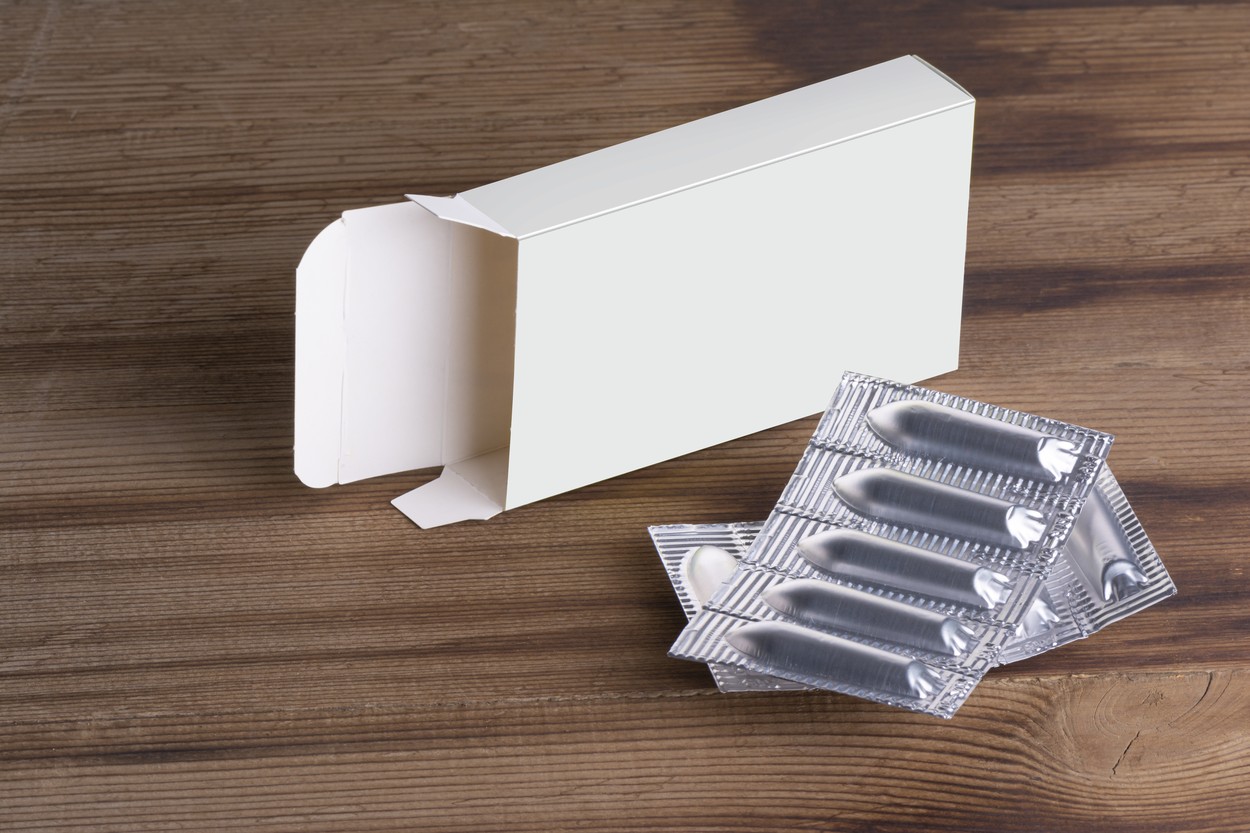 Suppositories loaf and an empty box on wooden table background mock-up series