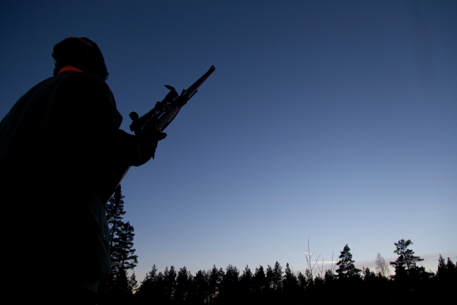 Hunter standing in the woods at night