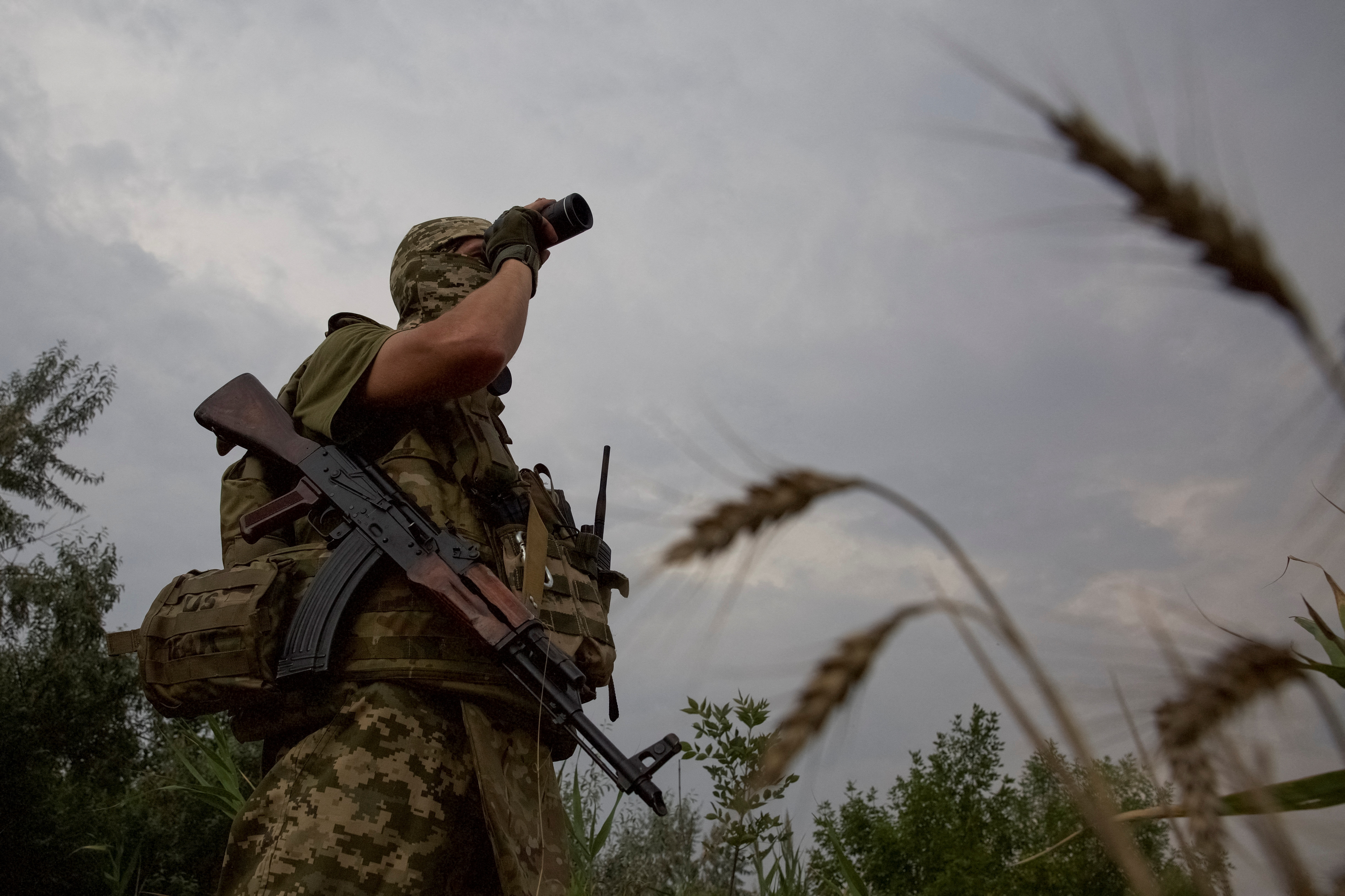 Ukrainian serviceman checks an area at a position in a front line in Mykolaiv region