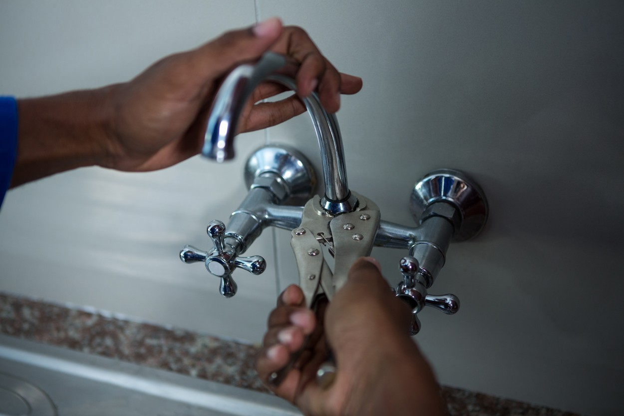 Close-up of plumber fixing the sink with wrench