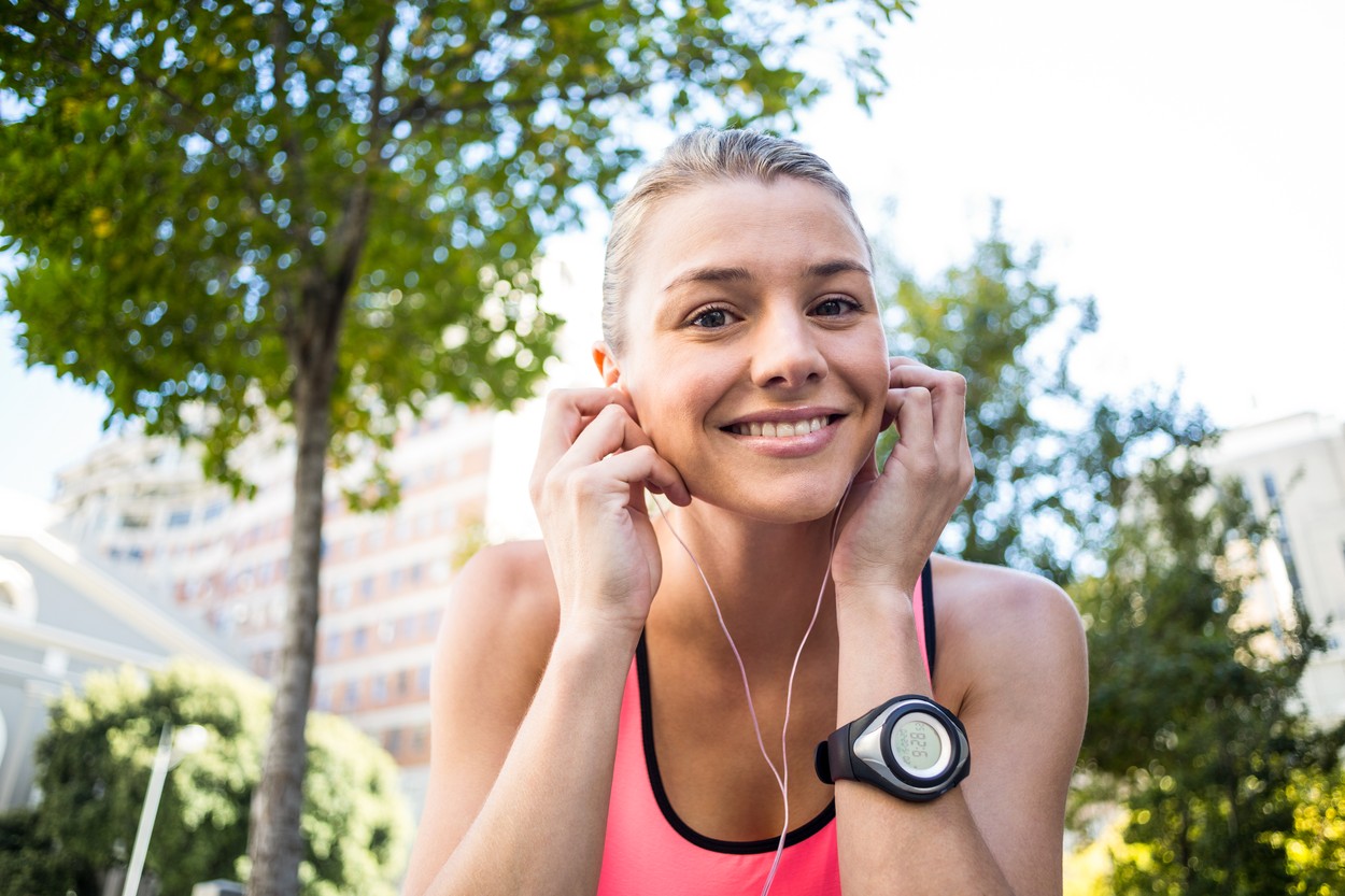 A beautiful athlete putting her headphones