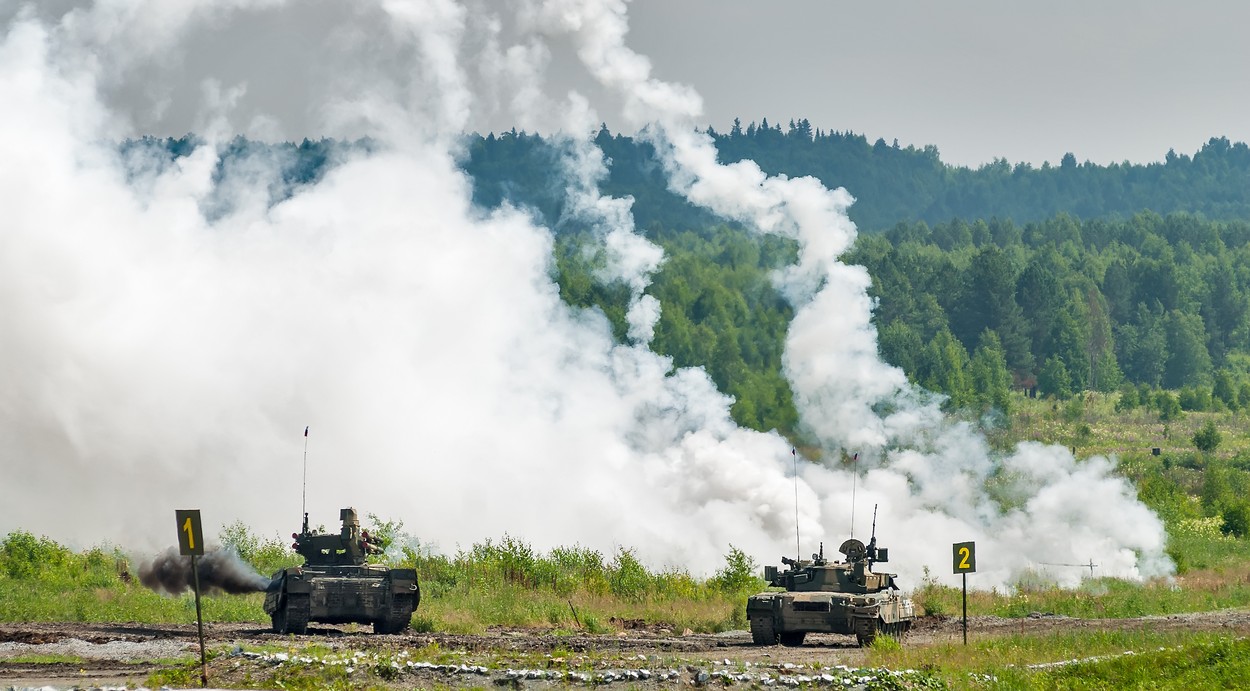 Military tanks hide behind smoke screen