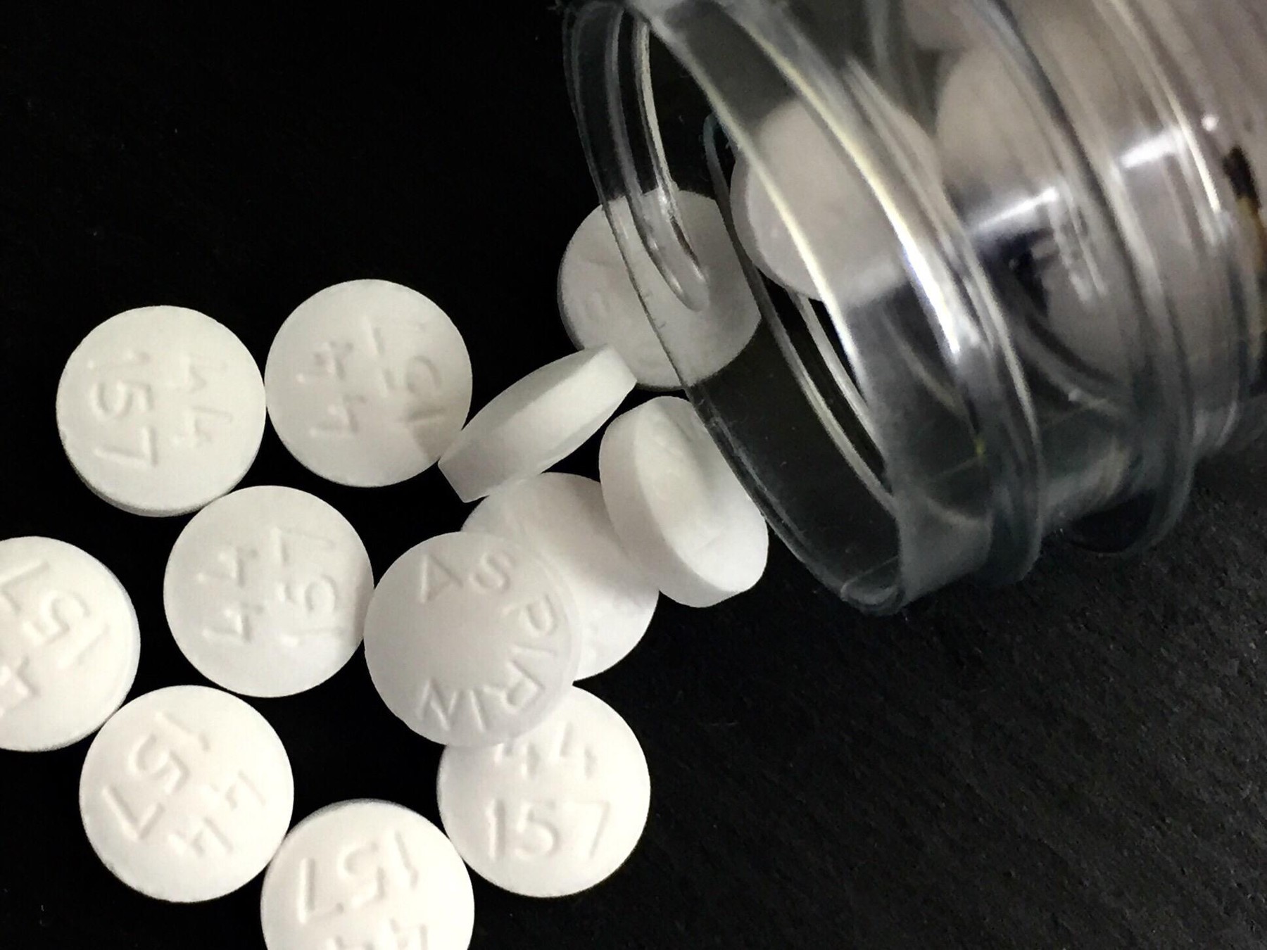 Aspirin pills on a black surface