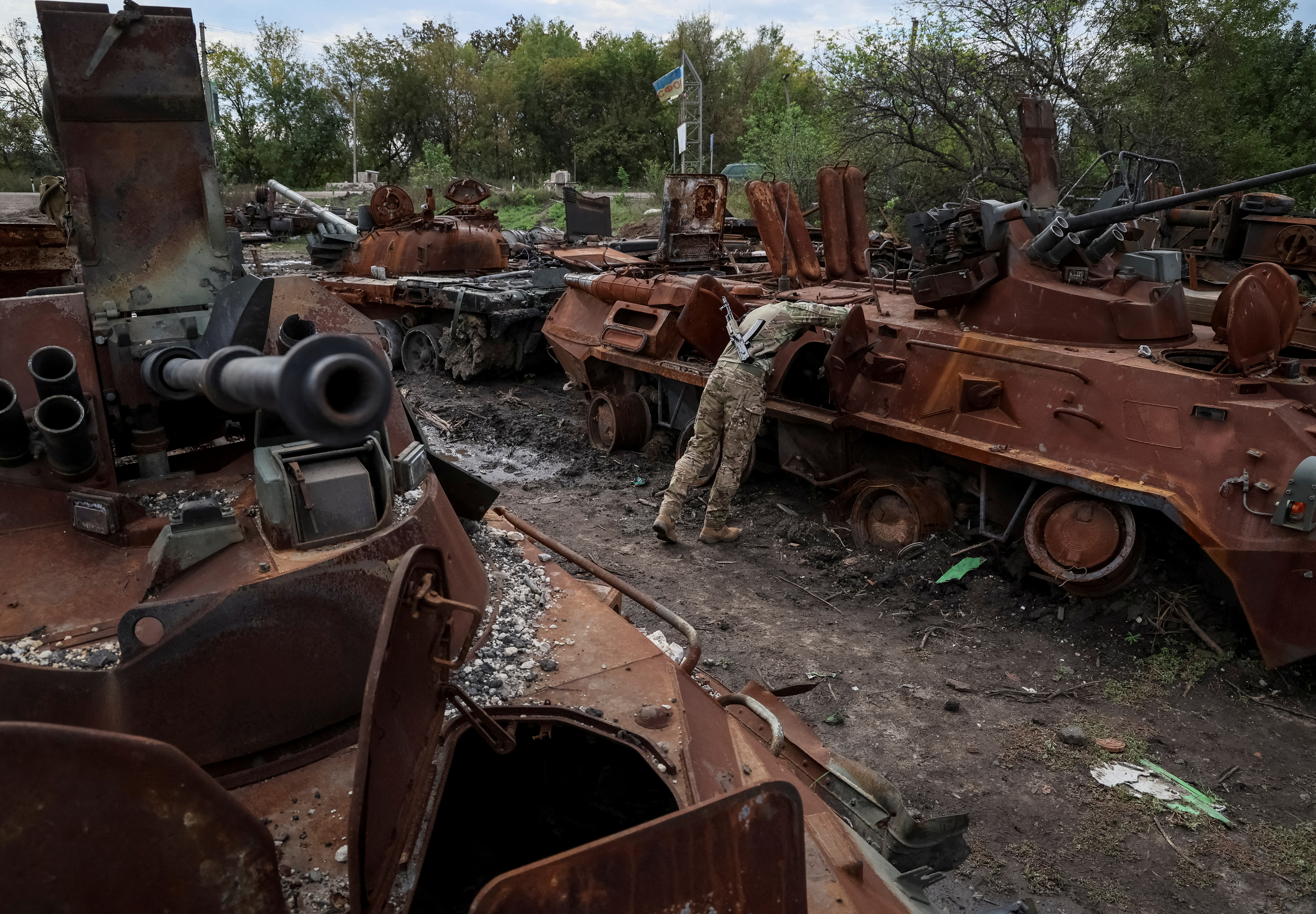 Ukrainian serviceman checks a destroyed Russian Armoured Personnel Carrier in the town of Izium