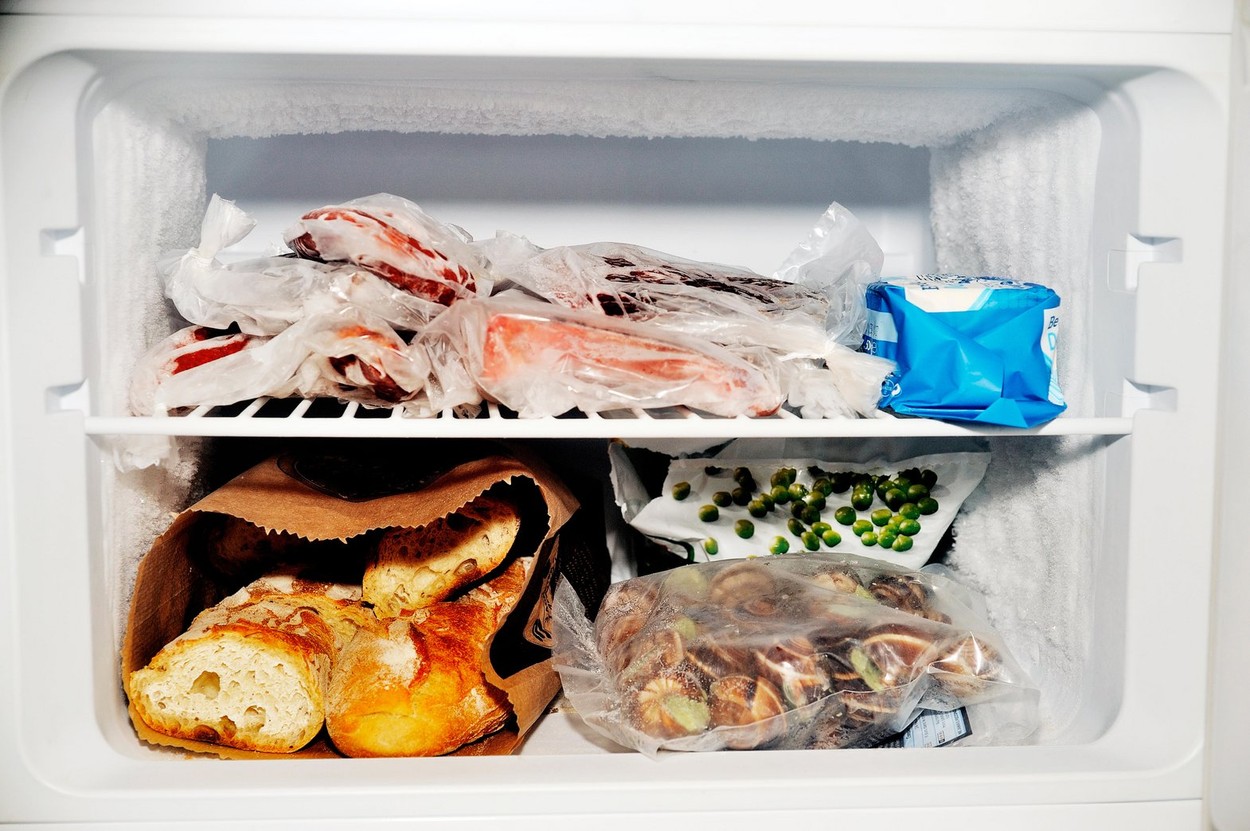 Freezer compartment of a refrigerator containing meat and frozen vegetables as well as bread