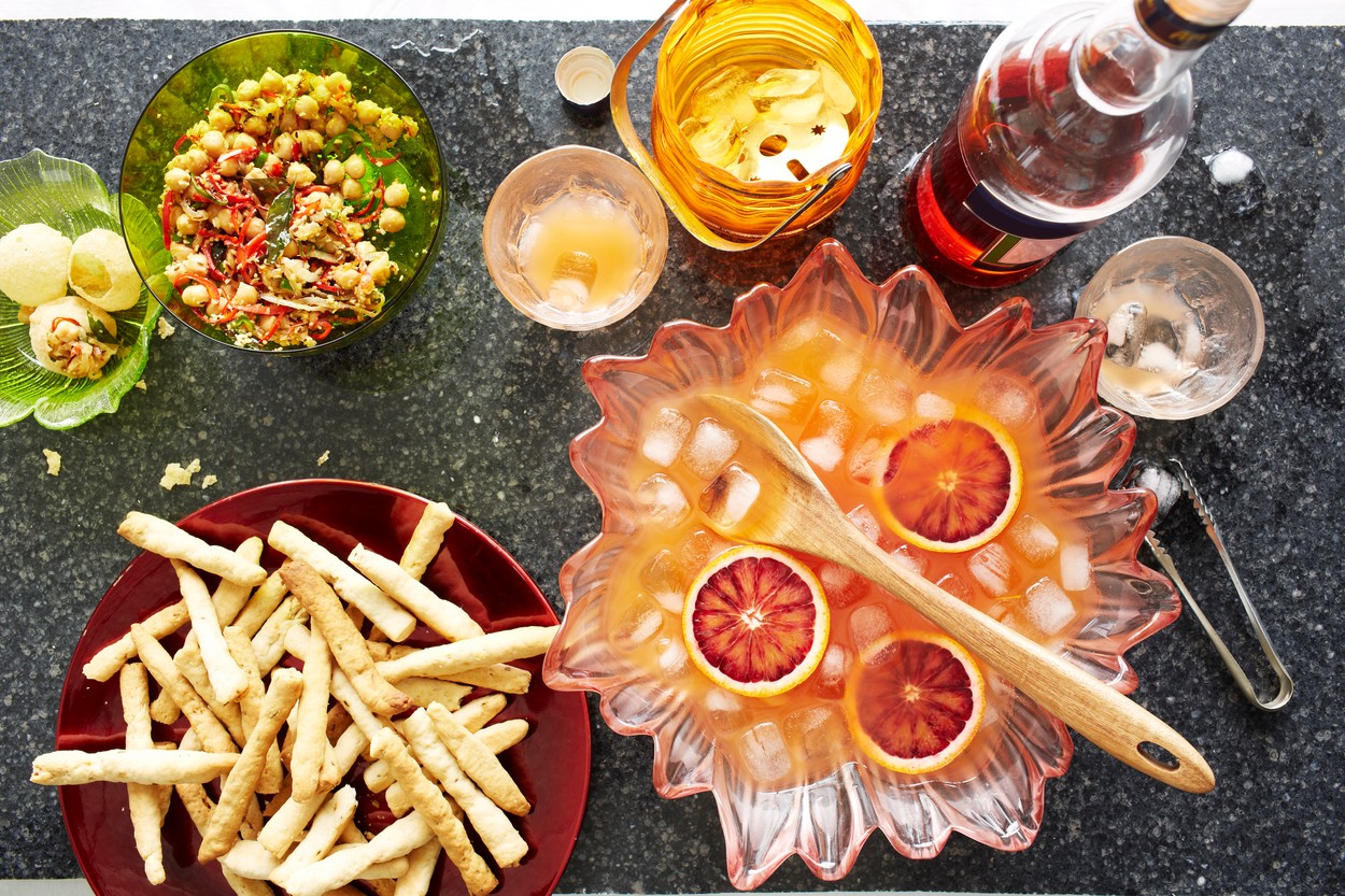 Still life of punch cocktail bowl with crisps and snacks