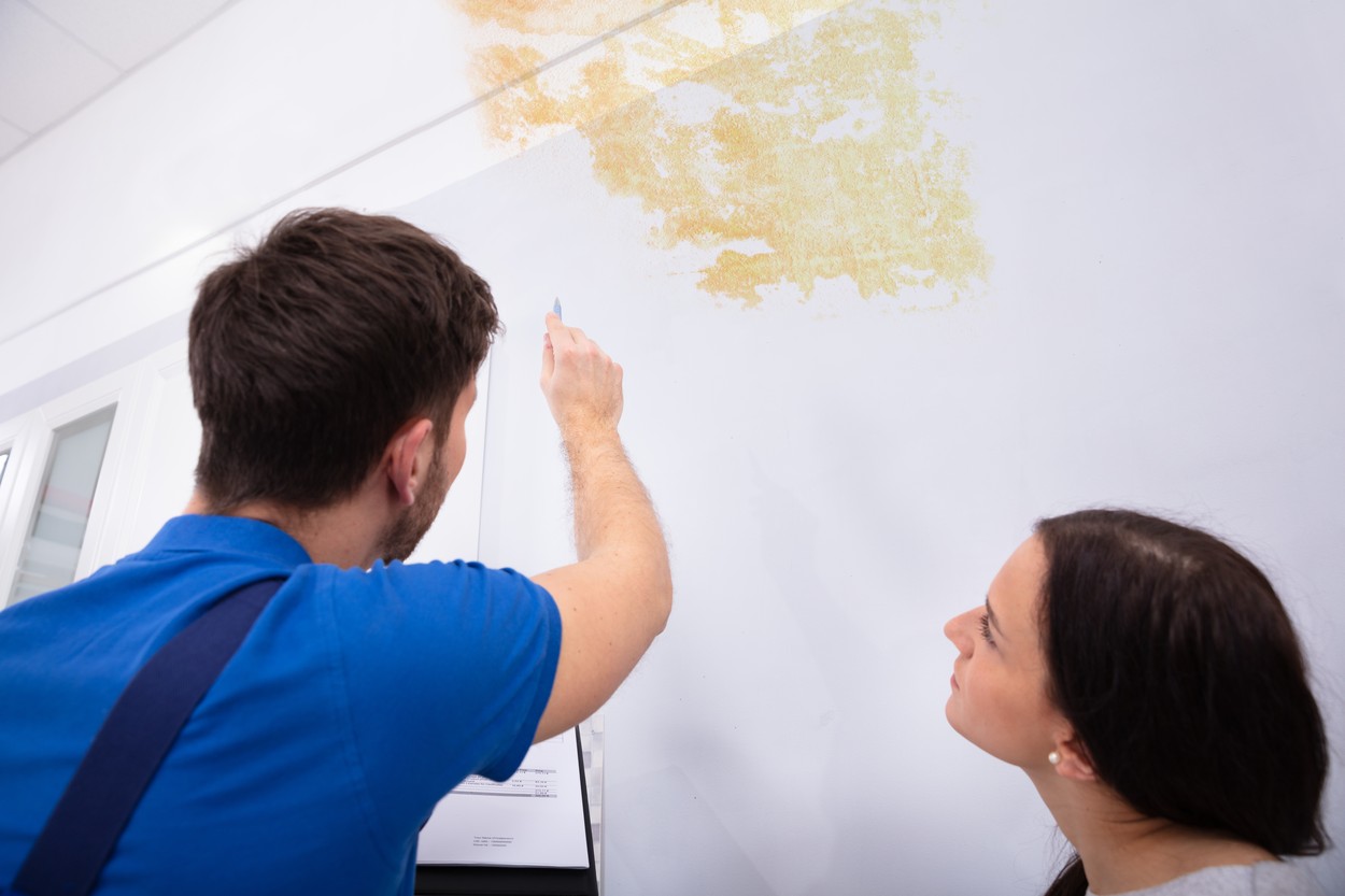 Worker Writing On Clipboard With Woman Standing