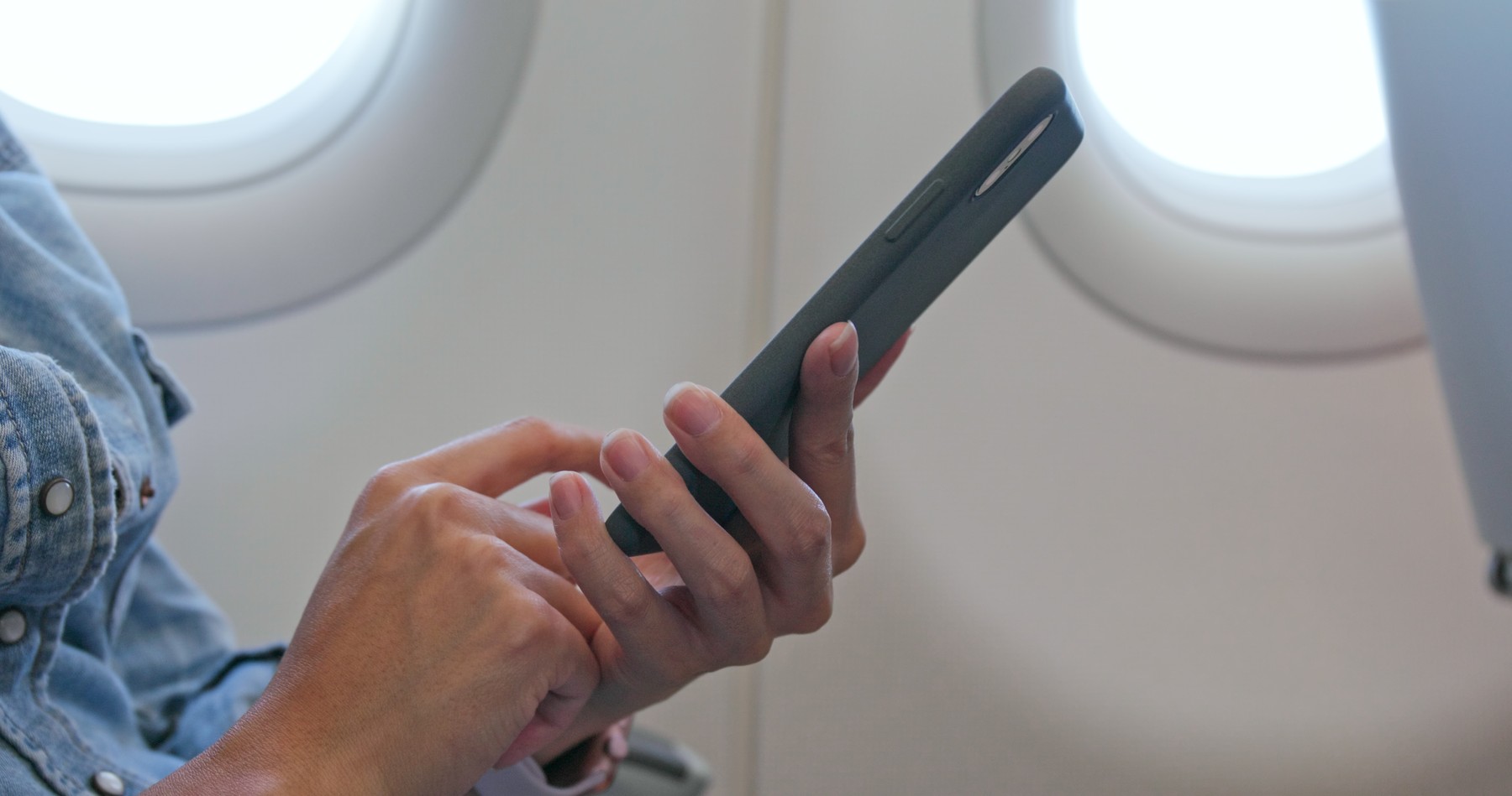 Woman use of mobile phone on plane