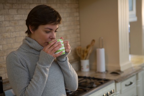 Woman drinking coffee in kitchen