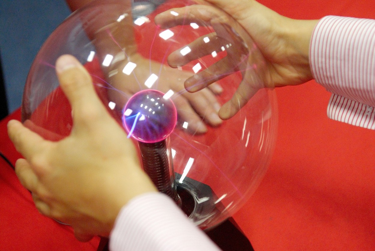 A child plays with a plasma ball.